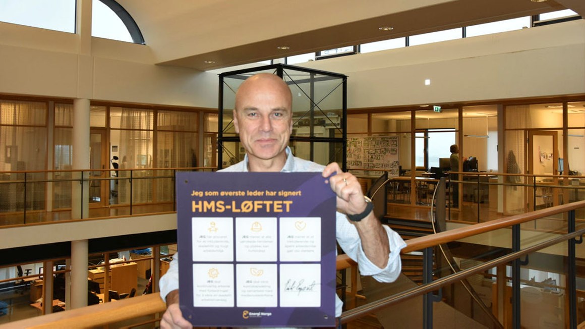 Erik Espeset daglig leder i Tafjord Kraft viser fram skiltet som sier at han har undertegnet  HMS-løftet. Foto