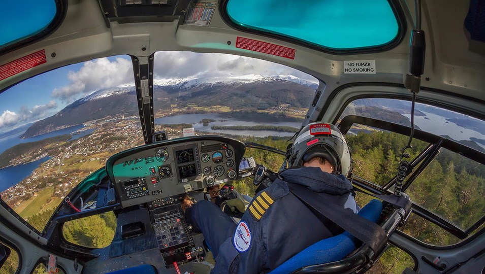 bildet av pilot i helikopeter og utsikt mot bakken