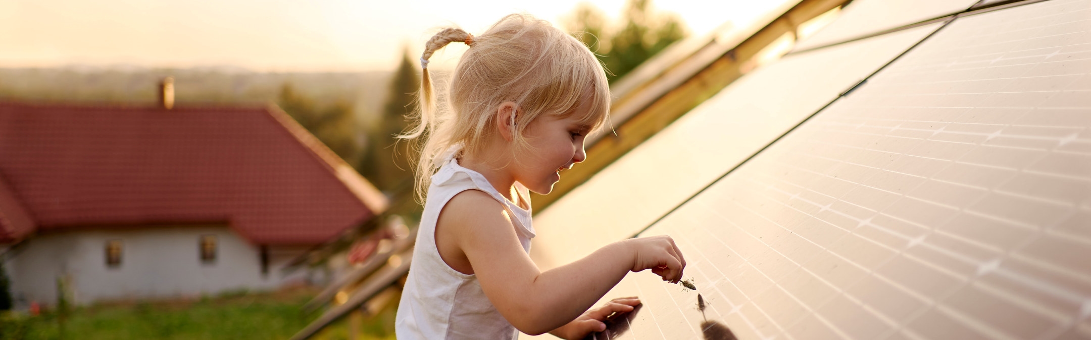 En liten jente tar på et tak med solceller.